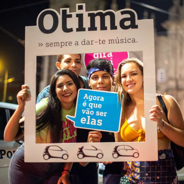 Pessoas a tirar uma fotografia com elementos gráficos de promoção à Otima Smart Porto